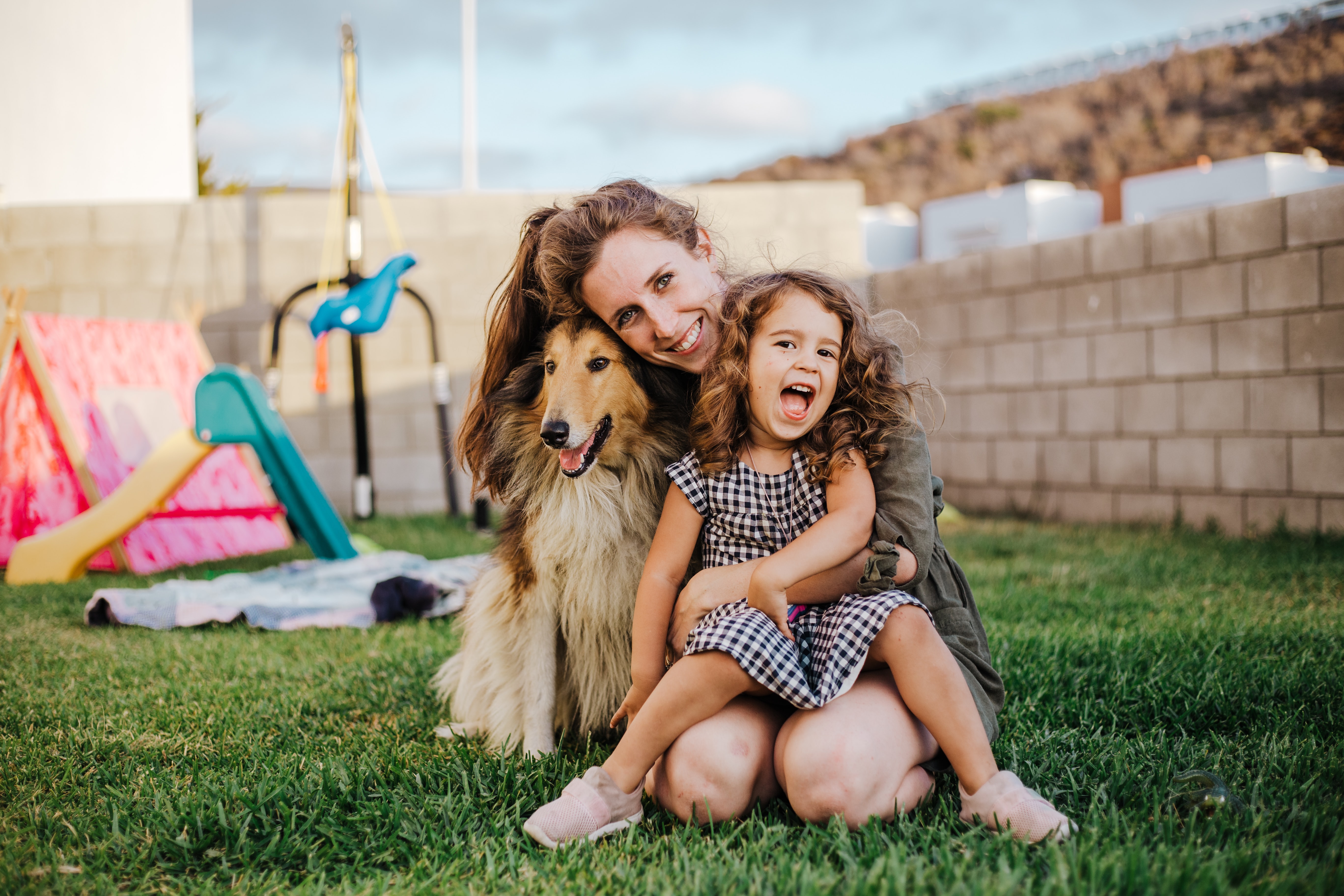 Madre e hija en el jardin con su perro